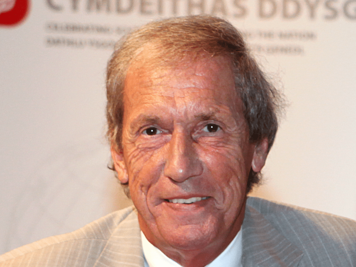 A headshot of Professor Geraint Jenkins FLSW, wearing a little suit jacket and smiling gently at the camera.